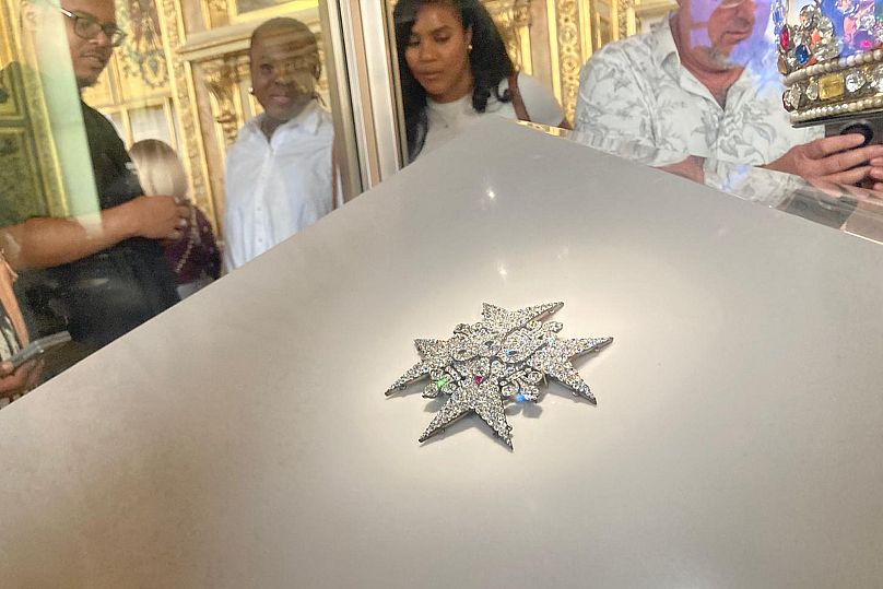 Visitors inspect jewellery in the Apollo Gallery of the Louvre museum on Sept. 4, 2025 in Paris. (AP Photo/Alexander Turnbull)