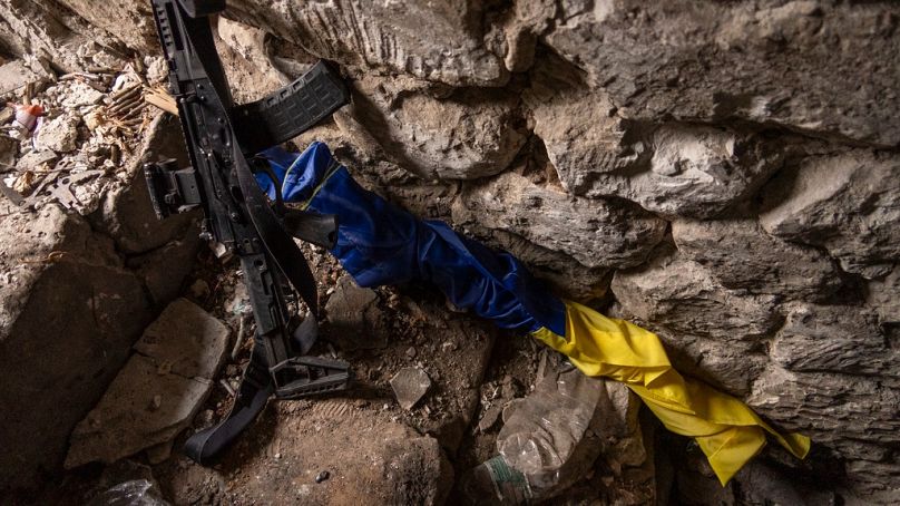 Eine ukrainische Flagge neben einem Gewehr in einem Bunker an einer Frontposition in Andrijiwka am 16. September 2023