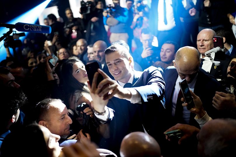 National Rally president Jordan Bardella takes a selfie with supporters at a meeting, in Marseille.