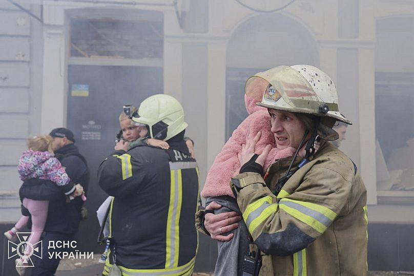 Des sauveteurs évacuent des enfants après que des drones russes ont frappé une maternelle lors d'une attaque à Kharkiv, en Ukraine, le mercredi 22 octobre 2025