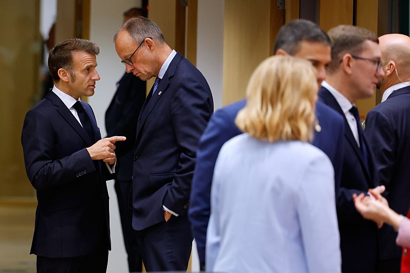 Der französische Präsident Emmanuel Macron, links, spricht mit dem deutschen Bundeskanzler Friedrich Merz, Mitte, bei einem EU-Gipfel in Brüssel, Donnerstag, 23. Oktober 2025.