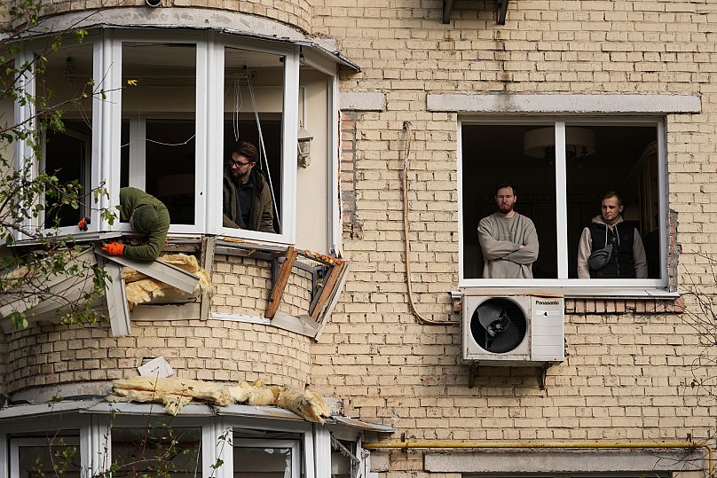Жители начинают восстанавливать поврежденный жилой дом после нападения России в Киеве, 23 октября 2025 года