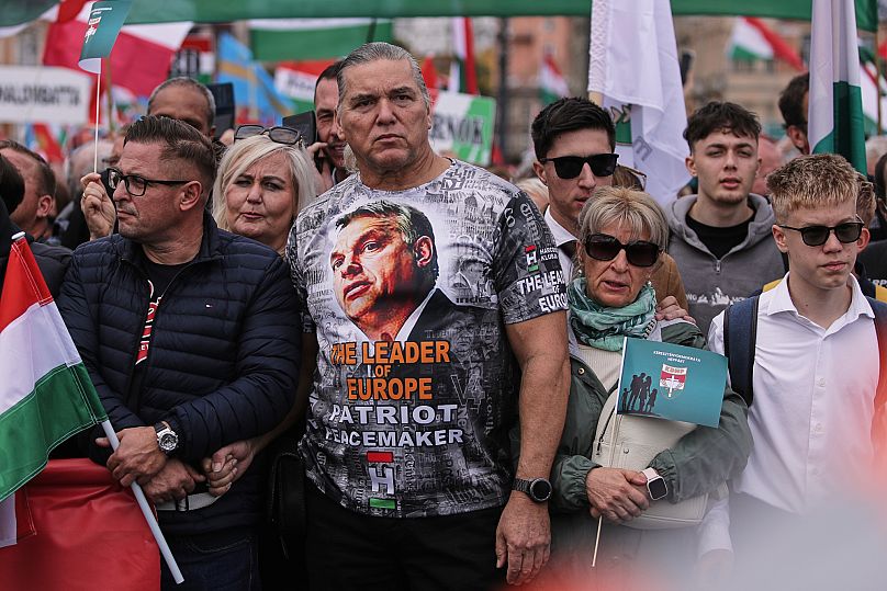 Un hombre con una camiseta del primer ministro húngaro, Viktor Orban, asiste a una marcha progubernamental en Budapest, Hungría, el jueves 23 de octubre de 2025.
