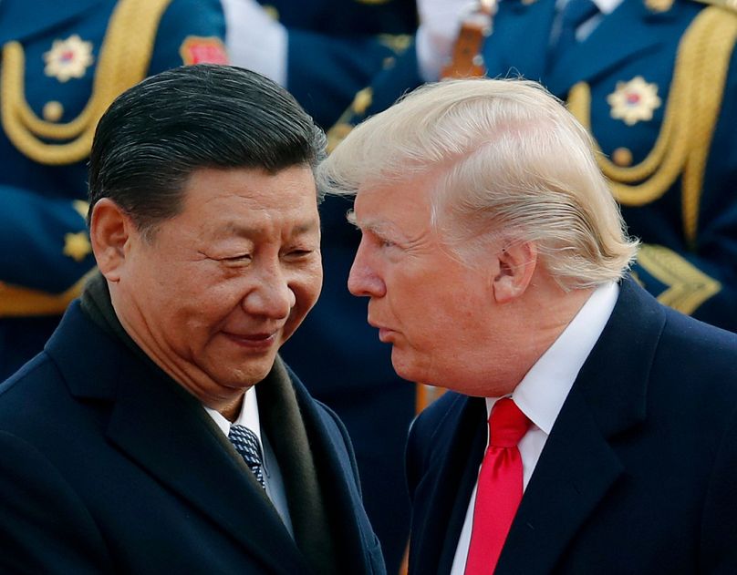 FILE - In this Nov. 9, 2017, file photo, U.S. President Donald Trump, right, chats with Chinese President Xi Jinping.