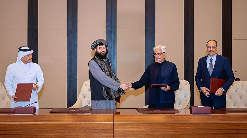 خواجه آصف، وزیر دفاع پاکستان (وسط سمت راست) و ملا محمد یعقوب، وزیر دفاع افغانستان، پس از امضای توافق آتشبس در دوحه، قطر، یکشنبه، ۱۹ اکتبر ۲۰۲۵، دست میدهند
