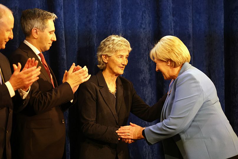 Catherine Connolly reçoit les félicitations de sa rivale, Heather Humphreys, sous le regard du Premier ministre et du vice-Premier ministre irlandais.