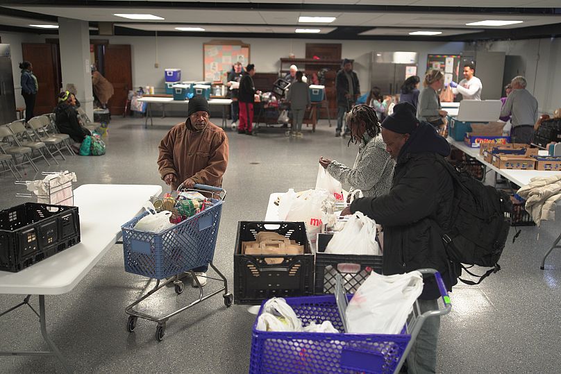 People bagging groceries they receive at the Central Christian Church food bank in Indianapolis, Saturday Oct. 25, 2025 (AP Photo/Obed Lamy)