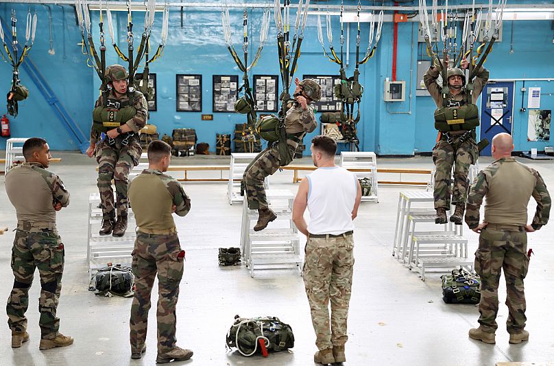 A British paratrooper instructs French paratroopers during a joint UK-French paratrooper training exercise at RAF Brize Norton, 7 July, 2025