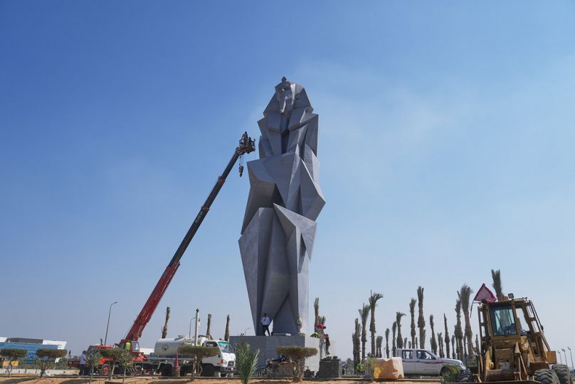 Gli operai dipingono la statua in ferro di 27 metri (89 piedi) "La guardia" dell'artista egiziana Deyaa Awed, che si troverà di fronte ai visitatori provenienti dall'aeroporto