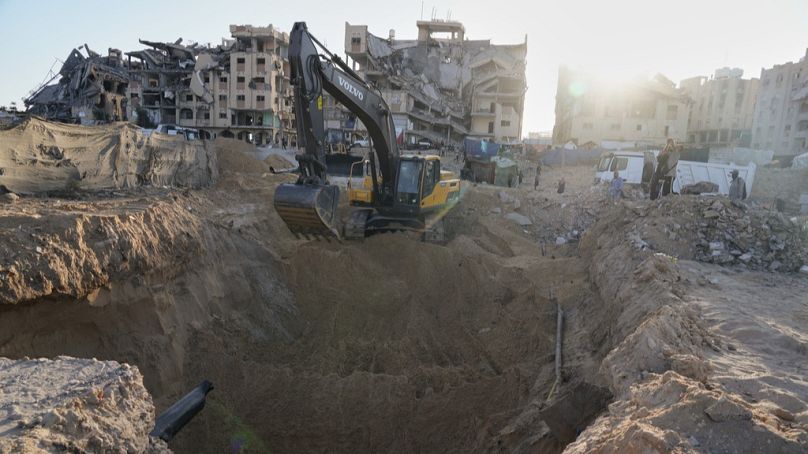 Palestinians watch machinery and some workers from Egypt searching for the bodies of hostages at Hamad City, in Khan Younis, southern Gaza Strip, Monday, Oct. 27, 2025.