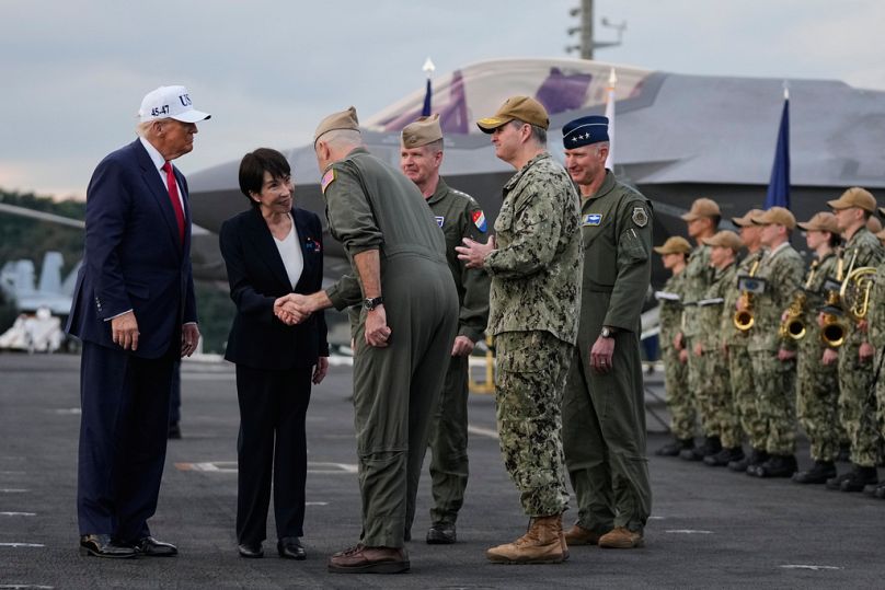 رئيسة وزراء اليابان سناي تاكايشي والرئيس ترامب يستقبلهما عناصر البحرية الأمريكية على متن USS George Washington في يوكوسوكا.