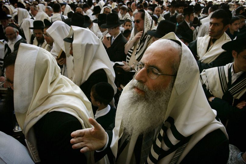 رجال يهود، بعضهم مُغطّى بشالات الصلاة، يصلّون بجوار الحائط الغربي، أقدس المواقع اليهودية، خلال صلاة الكهنة في البلدة القديمة بالقدس، الخميس 5 أبريل/نيسان 2007.
