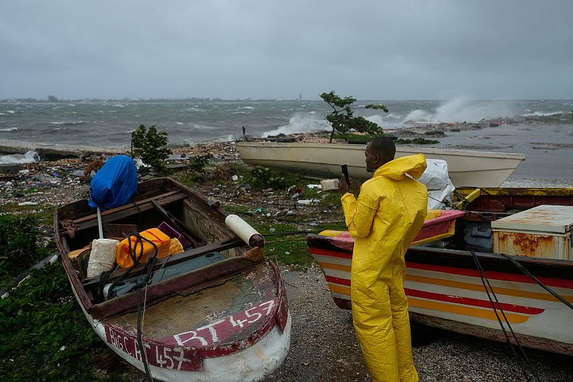 A man watches the coastline in Kingston, Jamaica, as Hurricane Melissa closes in, Tuesday, Oct. 28