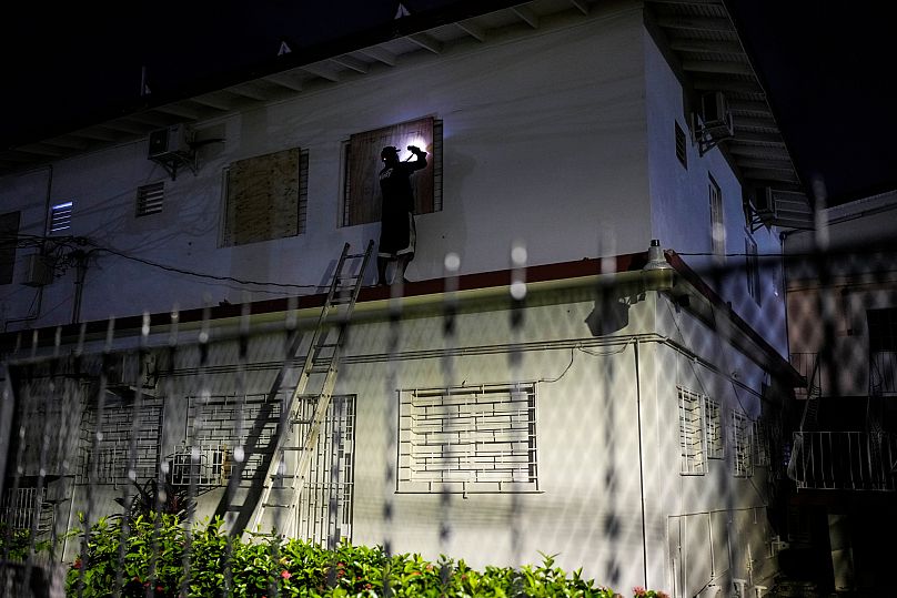 A man boards up a hotel's windows in preparation of Hurricane Melissa's expected arrival in Kingston