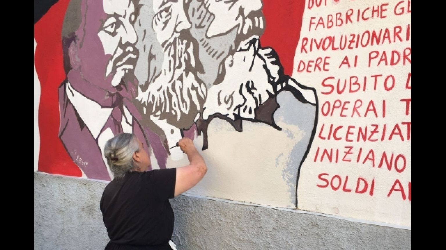 Anziana restaura murale a Orgosolo
