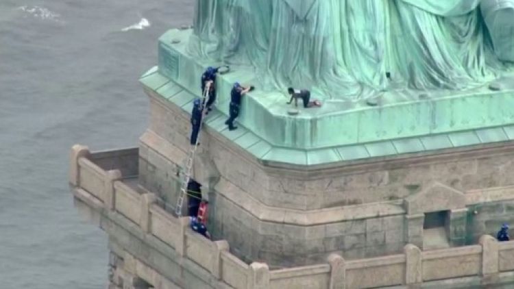 Opposée à la politique anti-immigrés de Trump, une femme gravit la Statue de la Liberté