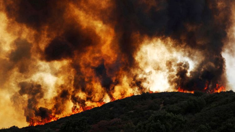 Crews battling deadly California wildfire slowed by returning winds