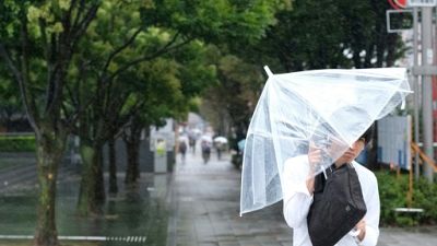 Un passant à Tokyo à l'approche du typhon Shanshan, le 8 août 2018 Un passant à Tokyo à l'approche du typhon Shanshan, le 8 août 2018