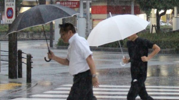 Des piétons sous la pluie à Tokushima au Japon, le 23 août 2018 Des piétons sous la pluie à Tokushima au Japon, le 23 août 2018