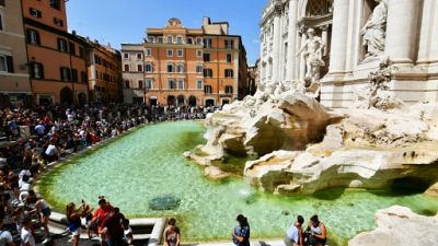 Des touristes devant la fontaine de Trévi à Rome, le 26 août 2018