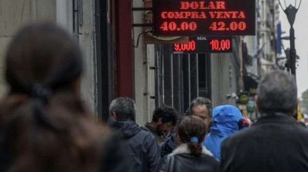 Des gens passent devant un bureau de change à Buenos Aires le 30 août 2018 Des gens passent devant un bureau de change à Buenos Aires le 30 août 2018