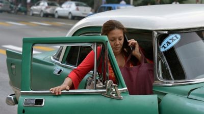 Une Cubaine monte à bord d'un taxi à La Havane le 17 janvier 2019 Une Cubaine monte à bord d'un taxi à La Havane le 17 janvier 2019