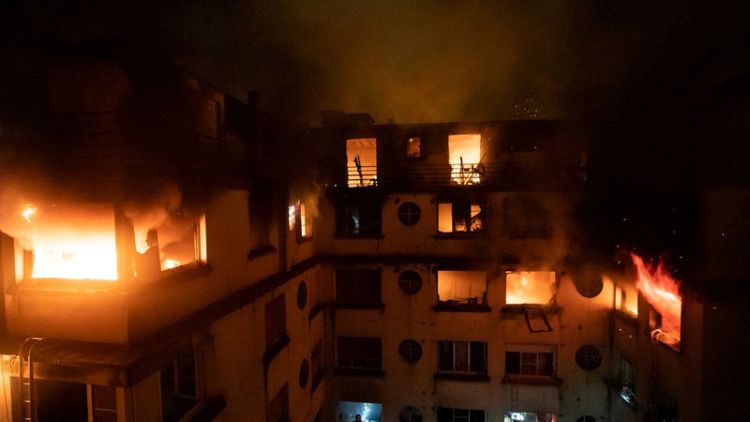 Woman held after blaze in chic Paris area kills 8, injures 30