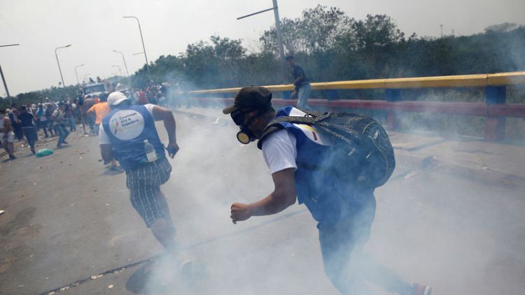 جيش فنزويلا يطلق قنابل الغاز خلال تفريغ حمولات مساعدات على الحدود