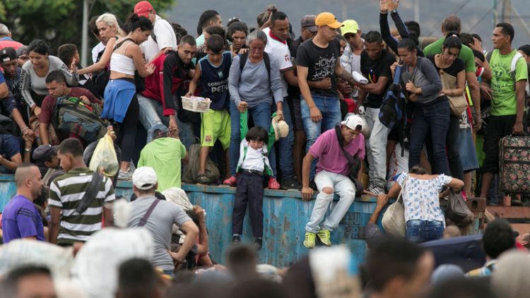 Thousands of Venezuelans break barricades, cross Colombia border
