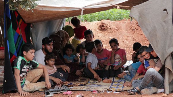 Fleeing into the fields, a family runs from Idlib attacks Fleeing into the fields, a family runs from Idlib attacks