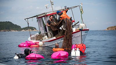 غواصون ينتشلون طنين من شباك الصيد المهملة من قاع البحر في اليونان