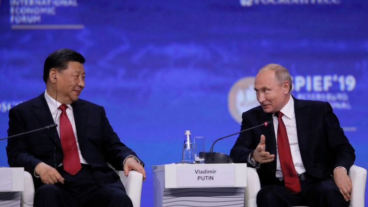 Putin stands by China, criticises U.S., in trade, Huawei disputes