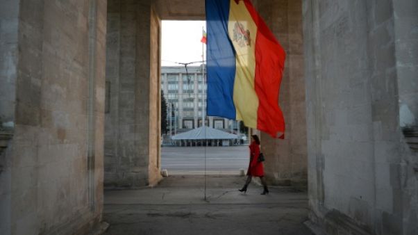 Une femme marche au pied d'un drapeau moldave à Chisinau, le 8 octobre 2013 Une femme marche au pied d'un drapeau moldave à Chisinau, le 8 octobre 2013