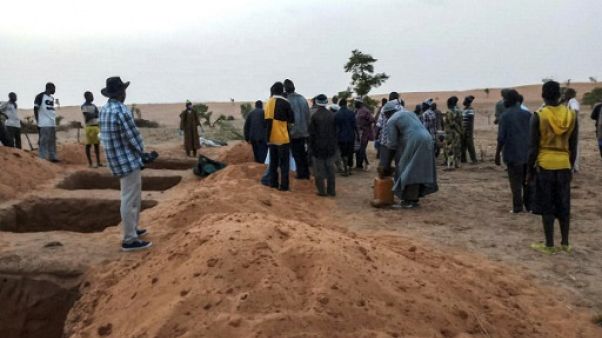 Des responsables et des habitants le 11 juin 2019 près de tombes fraichement creusées à Sobame Da, au Mali, où un massacre a fait une centaine de morts Des responsables et des habitants le 11 juin 2019 près de tombes fraichement creusées à Sobame Da, au Mali, où un massacre a fait une centaine de morts