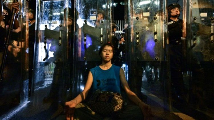 Une femme médite devant les forces de l'ordre, le 12 juin 2019 à Hong Kong