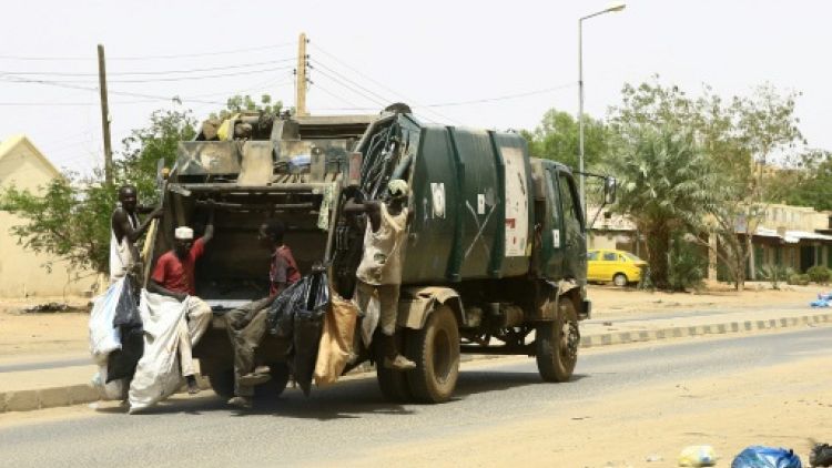 Des employés municipaux ramassent les ordures dans la capitale soudanaise Khartoum, le 12 juin 2019