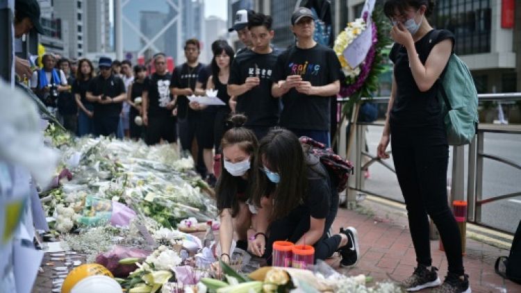 Fleurs et prières devant le lieu où est mort un opposant au projet de loi controversé autorisant les extraditions vers la Chine, à Hong Kong le 16 juin 2019
