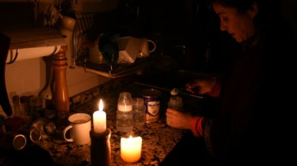 Une femme allume des bougies chez elle à Montevideo le 16 juin 2019 lors d'une panne d'électricité Une femme allume des bougies chez elle à Montevideo le 16 juin 2019 lors d'une panne d'électricité