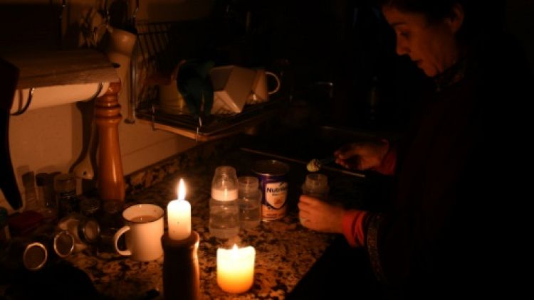 Une femme allume des bougies chez elle à Montevideo le 16 juin 2019 lors d'une panne d'électricité