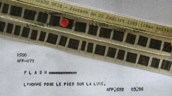 Photo, prise le 24 mai 2019, du flash de l'AFP annonçant le premier pas de l'homme sur la Lune, publié le 21 juillet 1969 à 02H56 GMT et conservé sur microfilm Photo, prise le 24 mai 2019, du flash de l'AFP annonçant le premier pas de l'homme sur la Lune, publié le 21 juillet 1969 à 02H56 GMT et conservé sur microfilm