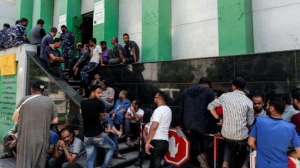 Des Palestiniens font la queue devant un bureau de poste pour recevoir une aide financière du Qatar, à Gaza, le 17 juin 2019 Des Palestiniens font la queue devant un bureau de poste pour recevoir une aide financière du Qatar, à Gaza, le 17 juin 2019
