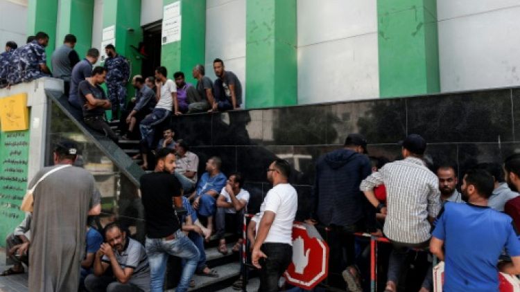 Des Palestiniens font la queue devant un bureau de poste pour recevoir une aide financière du Qatar, à Gaza, le 17 juin 2019