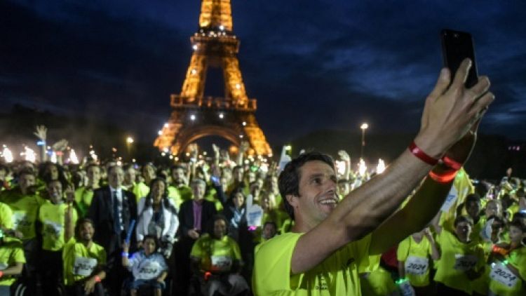 Le patron du Comité d'organisation de Paris-2024 Tony Estanguet prend un selfie avec les participants à la Journée olympique, le 23 juin 2018 à Paris
