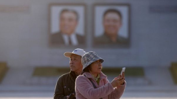 Des touristes chinois prennent des photos sur la place Kim Il Sung à Pyongyang, le 14 avril 2019 en Corée du Nord Des touristes chinois prennent des photos sur la place Kim Il Sung à Pyongyang, le 14 avril 2019 en Corée du Nord
