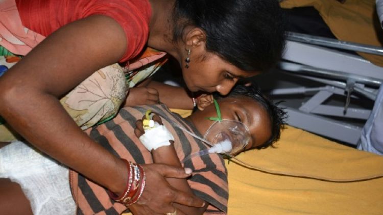 Une mère auprès de son enfant atteint d'encéphalite aigüe, le 17 juin 2019 à l'hôpital universitaire public Sri Krishna, à Muzzafarpur, dans le nord de l'Inde