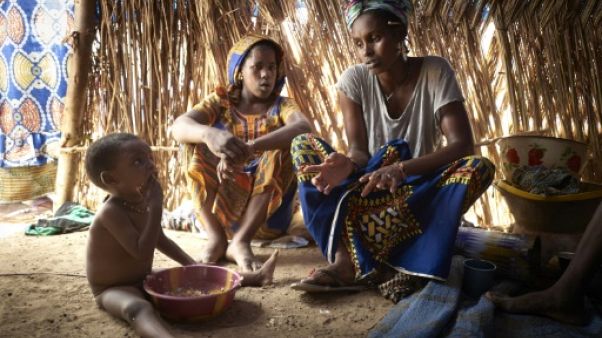 Une mère et ses enfants, de la communauté peule, sous une tente d'un camp de réfugiés installé dans la banlieue de Bamako, le 8 mai 2019 Une mère et ses enfants, de la communauté peule, sous une tente d'un camp de réfugiés installé dans la banlieue de Bamako, le 8 mai 2019
