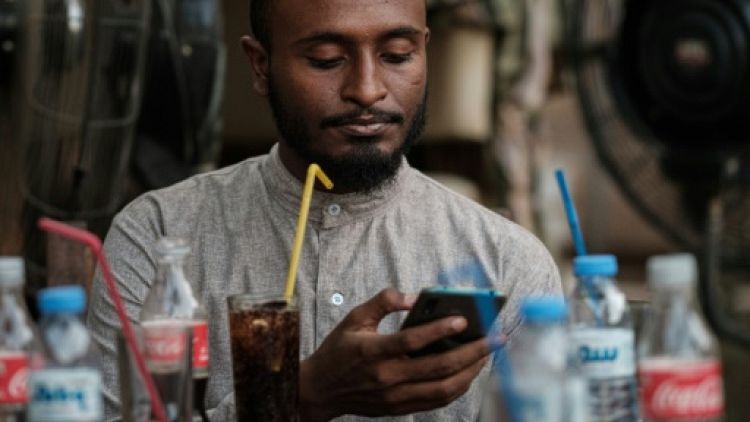 Un jeune Soudanais consulte sur téléphone portable, le 17 juin 2019 dans un café de Khartoum