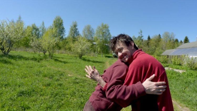 Svetlana, 35 ans, et Dima, 34 ans, se donnent l'accolade dans un champ de la ferme thérapeutique  près du village d'Aleksino (Russie), le 18 mai 2019
