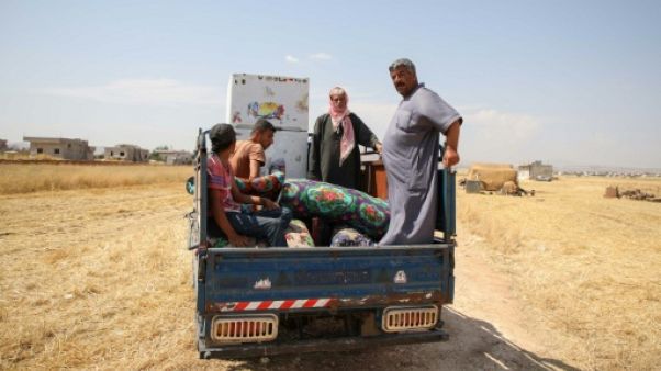 Des déplacés syriens transportent à bord d'un pick-up des affaires pour les vendre dans les environs de la ville d'Abyane, dans la province d'Alep (nord) le 13 juin 2019 Des déplacés syriens transportent à bord d'un pick-up des affaires pour les vendre dans les environs de la ville d'Abyane, dans la province d'Alep (nord) le 13 juin 2019