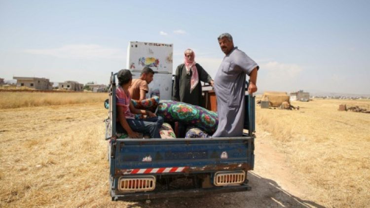 Des déplacés syriens transportent à bord d'un pick-up des affaires pour les vendre dans les environs de la ville d'Abyane, dans la province d'Alep (nord) le 13 juin 2019